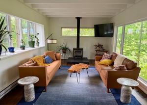 a living room with two couches and a tv at Manville Heights Modern in Iowa City