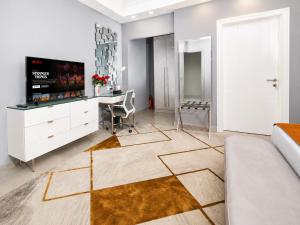 a living room with a tv and a table and a couch at The Alima Suites in Accra