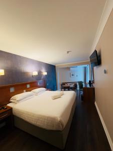 a hotel room with a large bed and a table at Imperial Hotel Galway in Galway