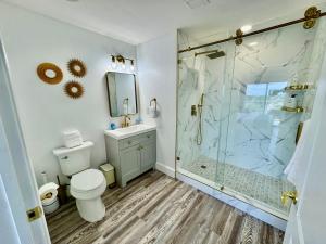 a bathroom with a toilet and a glass shower at Balcony Lake Views - Pool, Gym, WiFi & Parking in Orlando +176 photos