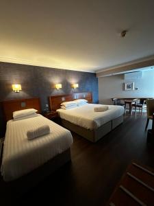 a hotel room with two beds and a table at Imperial Hotel Galway in Galway