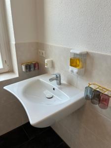 a white sink in a bathroom with a window at MartiniRoom Signature in Glauchau +15 photos