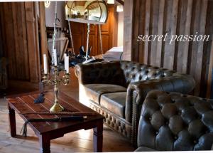 a living room with a leather couch and a coffee table at Romantisches SM Apartment Secret Passion in Fehmarn +2 photos