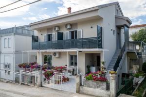 a white house with a balcony and flowers at Guest house AnĐela in Neum