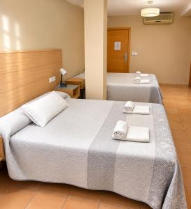 two beds in a hotel room with towels on them at Hotel Sierra de Huesa in Huesa +48 photos