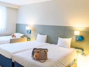 a hotel room with two beds with a bag on the bed at ibis Styles Tours Centre in Tours +237 photos