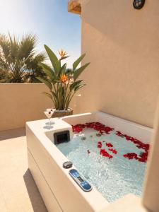 eine mit roten Blumen gefüllte Badewanne im Badezimmer in der Unterkunft Eva Beach Hotel Lefkada in Nydri