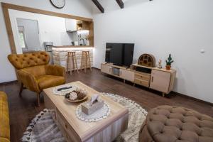 a living room with a couch and a table and a tv at Kosmaj Apartmani Košutica - Marija i Ksenija in Koraćica
