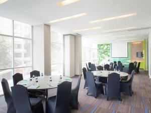 a conference room with tables and chairs and windows at All Seasons Jakarta Thamrin in Jakarta