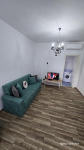 ein Wohnzimmer mit einer grünen Couch und einem Tisch in der Unterkunft Villa ASTERA in Pefkari
