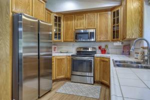 a kitchen with wooden cabinets and stainless steel appliances at Tahoe Forest Haven in South Lake Tahoe +25 photos