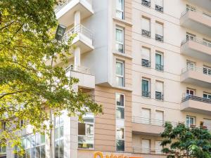 an apartment building with balconies and trees at Aparthotel Adagio Access La Défense - Place Charras in Courbevoie