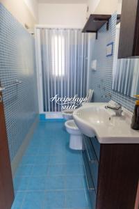 a blue bathroom with a sink and a toilet at Arcipelago Suite in Belvedere Marittimo +68 photos
