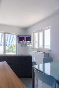 a living room with a table and chairs and windows at Arcipelago Suite in Belvedere Marittimo
