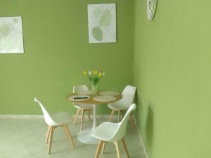 a table and chairs in a room with a green wall at Casa Rosa in Vigevano