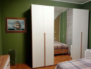 a bedroom with green walls and a white cabinet at Casa Rosa in Vigevano