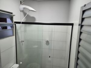 a shower with a glass door in a bathroom at loft 2 em Salto Acomoda até 4 pessoas rede urbana in Salto