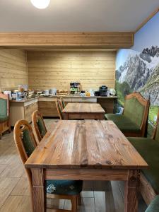 a dining room with a wooden table and chairs at Kłabuk in Białka Tatrzańska