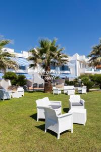 a group of white chairs and tables in a park at Arcipelago Suite in Belvedere Marittimo