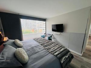 a bedroom with a large bed with a large window at Exclusive and Secure Apartment Parque Arauco Las Condes in Santiago