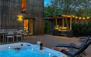 a backyard with a hot tub and a table and chairs at La Râu 663A - Riverside Mountain Chalet with Outdoor Jacuzzi in Porumbacu de Sus