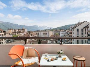 a table and chairs on a balcony with a view at ibis Styles Annecy Centre Gare in Annecy