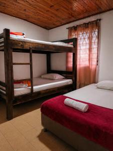a bedroom with two bunk beds and a red mattress at Complejo Campestre Salome Cabañas & Hotel in Calima