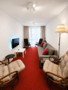 a living room with chairs and a couch and a tv at Apartament Okuninka DINA20 in Okuninka
