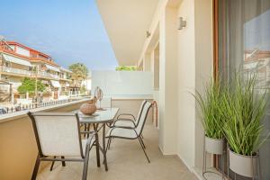 a balcony with a table and chairs and plants at IFESTOS APARTMENTS in Ierissos