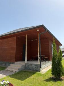 a wooden building with two picnic tables in it at Kausar cottage in Cholpon-Ata