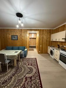 a living room with a blue couch and a table at Kausar cottage in Cholpon-Ata