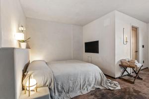 a white bedroom with a bed and a table at Kit inn Wetrock in Moab