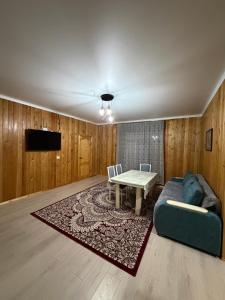 a living room with a couch and a table at Kausar cottage in Cholpon-Ata