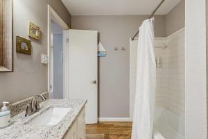 a bathroom with a shower and a sink and a tub at Dog-Friendly Lakefront Home with Private Sundeck in Kingsland +17 photos