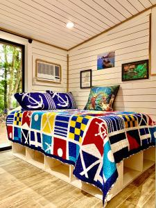 a bedroom with a bed with a colorful comforter at Camp Squid Off The Grid in Benzonia