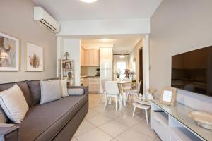 a living room with a couch and a dining room at IFESTOS APARTMENTS in Ierissos