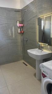 a bathroom with a sink and a shower with a mirror at Ayzal Apartment in Shëngjin +13 photos