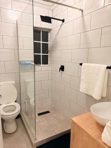 a bathroom with a toilet and a glass shower at Kilimanjaro in Alberton