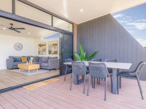 a dining room and living room with a table and chairs at Wairo Beach Holiday Park in Lake Tabourie
