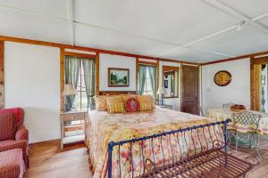 a bedroom with a large bed and a chair at Historic Lakefront & Wildlife Haven with Firepit & Gas Grill - Minutes to Water in Burnet