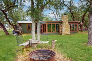a house with chairs and a fireplace in a yard at Historic Lakefront & Wildlife Haven with Firepit & Gas Grill - Minutes to Water in Burnet