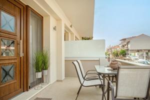 a balcony with a table and chairs and a whiteboard at IFESTOS APARTMENTS in Ierissos