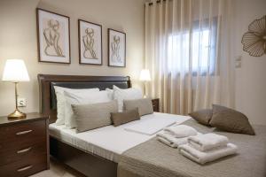 a bedroom with a large bed with towels on it at IFESTOS APARTMENTS in Ierissos