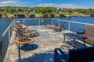 a deck with chairs and a table on the water at Lakefront Home with WiFi, Entertainment, Dock & Lake Views - Dogs OK in Buchanan Dam