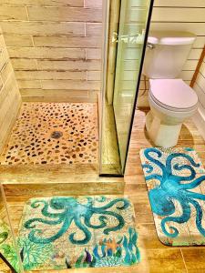 a bathroom with a toilet and an octopus rug at Camp Squid Off The Grid in Benzonia