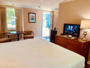 a hotel room with a bed and a television at The Chatham Motel in Chatham
