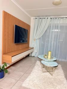 a living room with a tv and a table at Kilimanjaro in Alberton