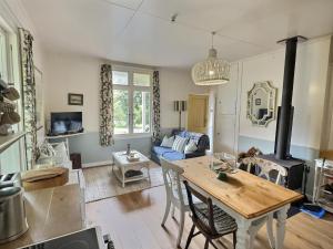 a living room with a table and a wood stove at The Rabbiter's Cottage in Kahuranaki