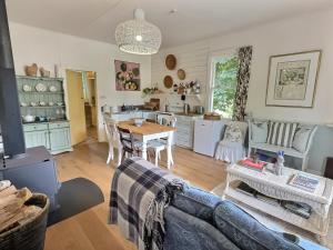 a living room with a couch and a table at The Rabbiter's Cottage in Kahuranaki