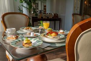 a table with plates of food and orange juice at Villa do Vale Boutique Hotel in Blumenau